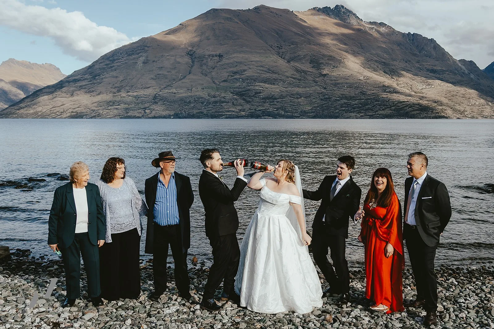 Small family group gathered at a shoreline ceremony on Lake Wakatipu below Cecil Peak