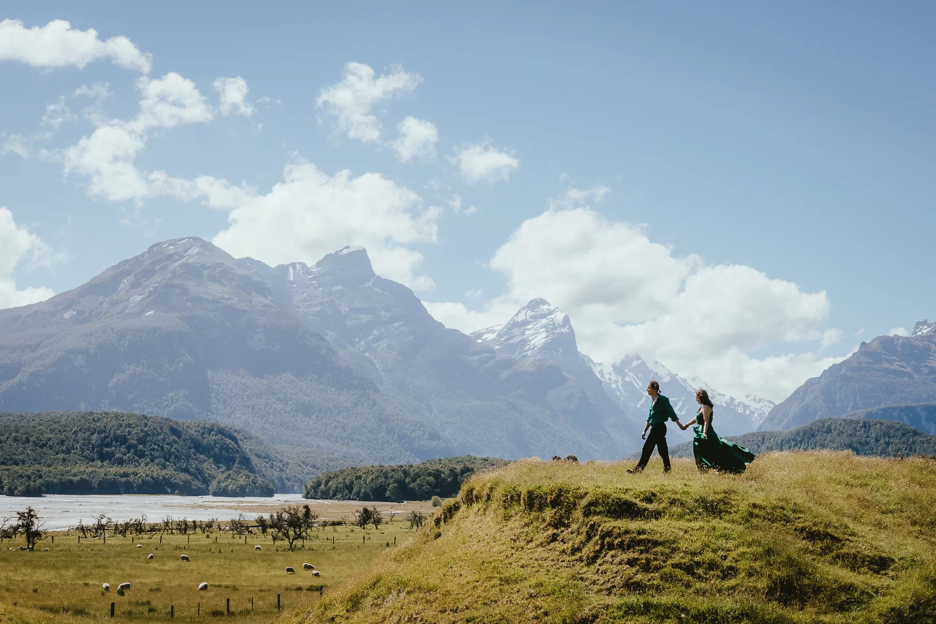Couple walking through the Glenorchy valley with mountains behind them