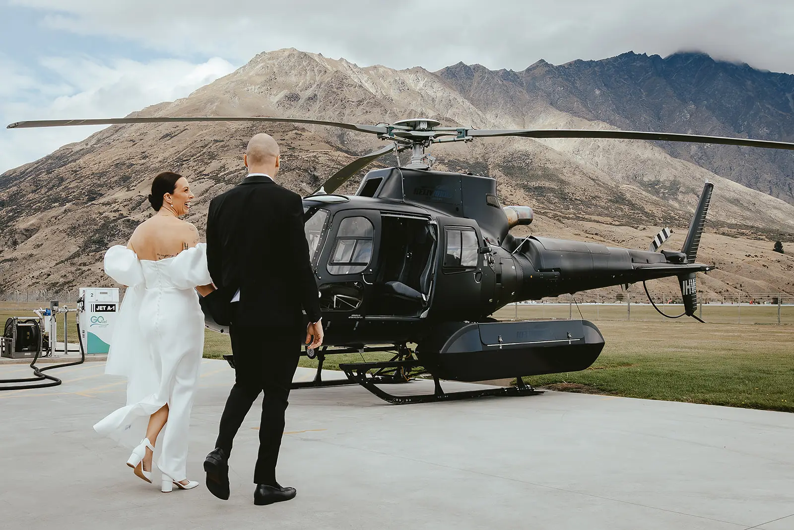 Couple walking towards a black helicopter in the Remarkables