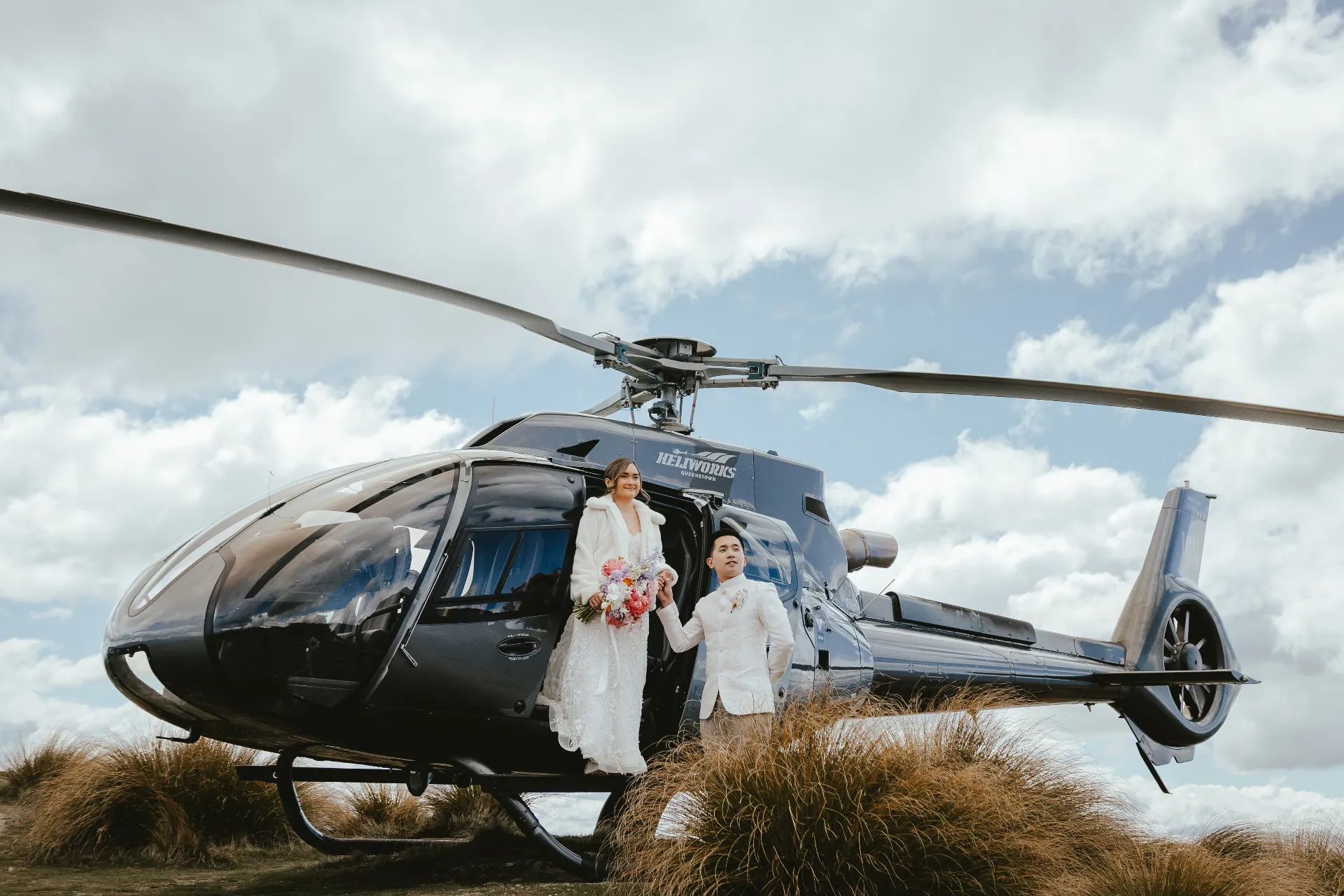 Couple stepping out of a helicopter onto a glacier during a Queenstown elopement