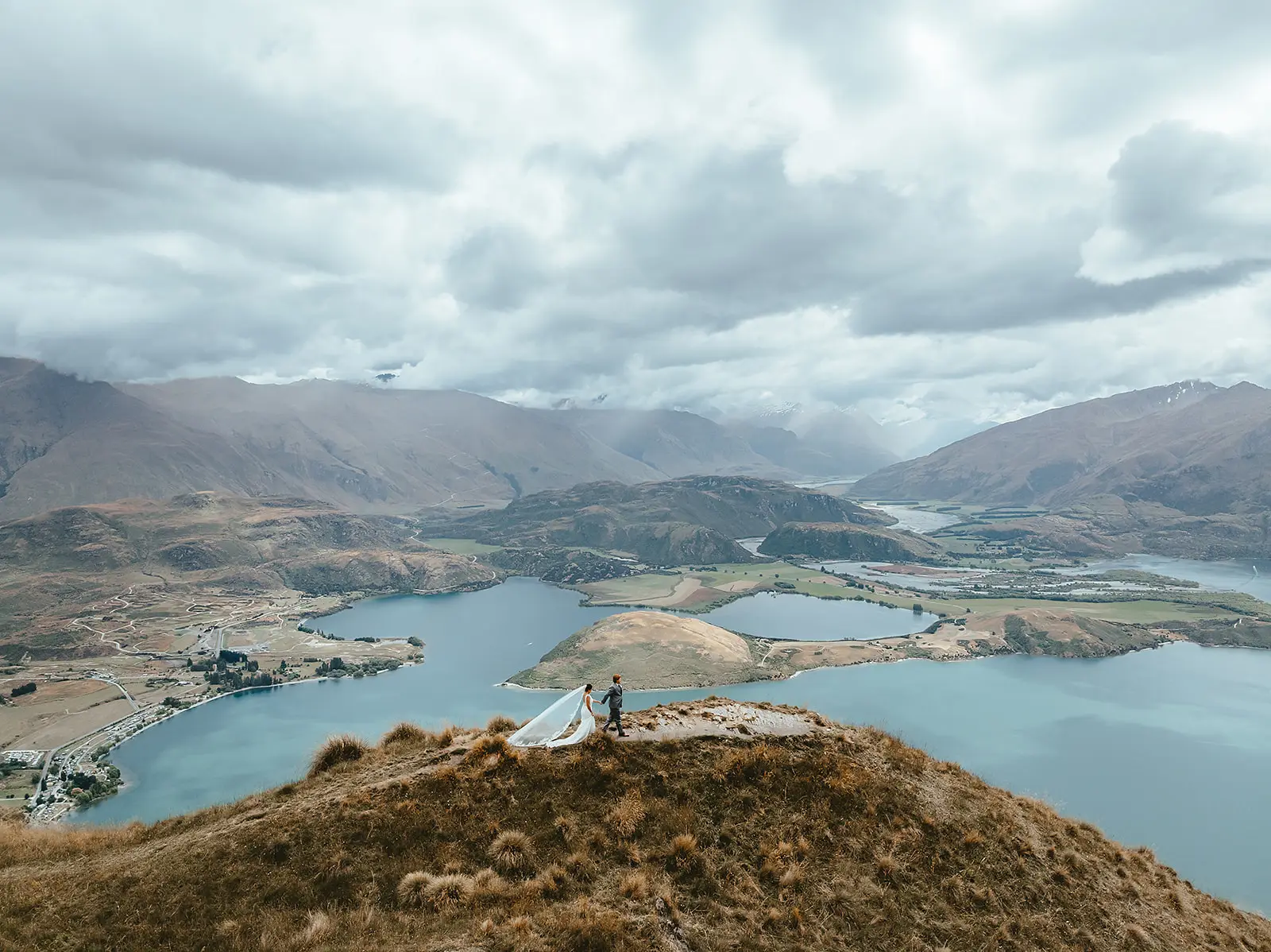 Couple walking the summit of Coromandel Peak above Lake Wanaka