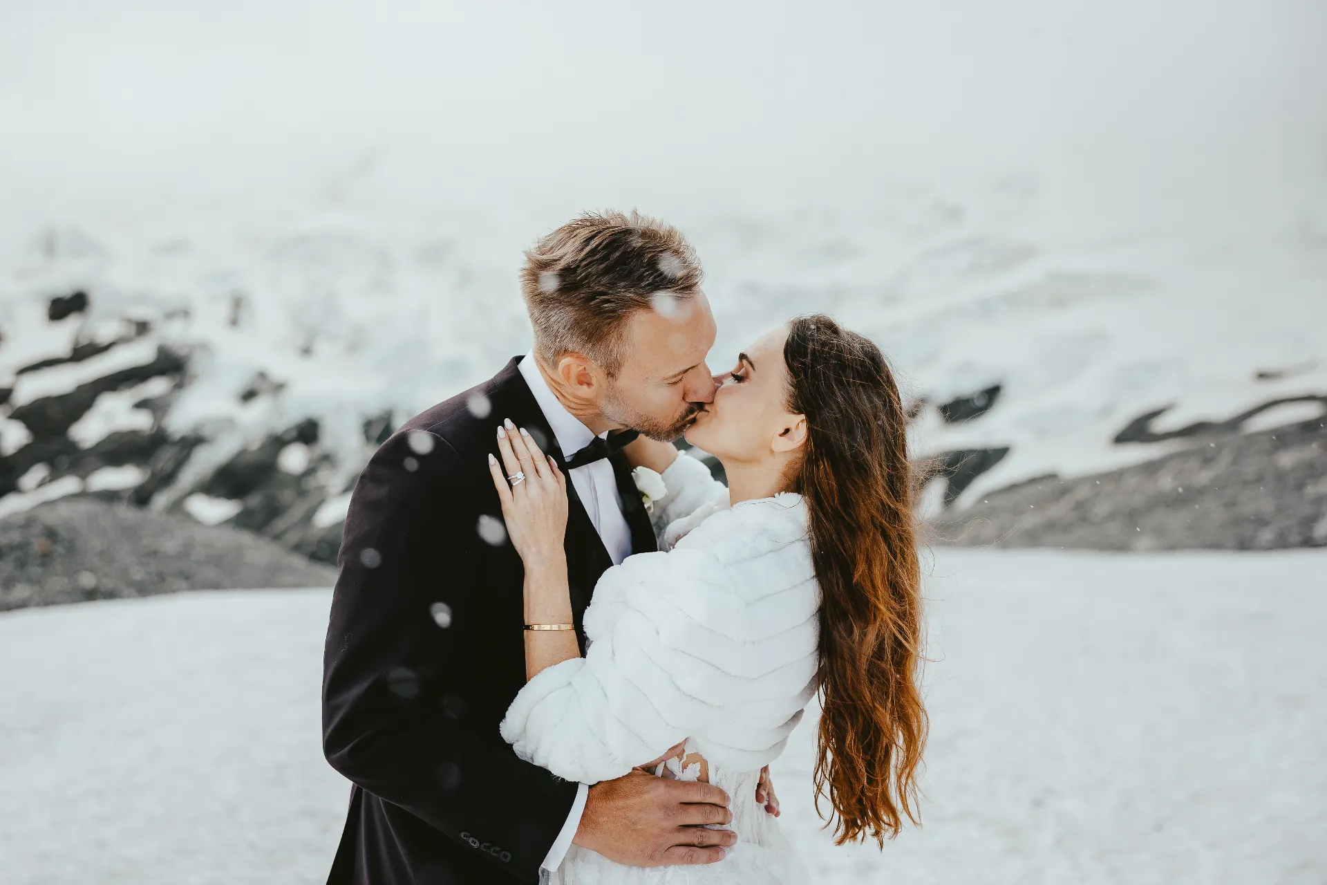 Couple kissing on a snow-covered peak during a Queenstown winter elopement