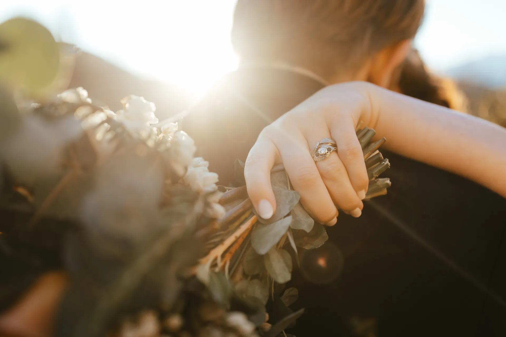 Wedding rings resting on a bouquet in golden light at a Queenstown elopement